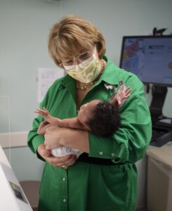 nurse Lauren Gibbs holds newborn